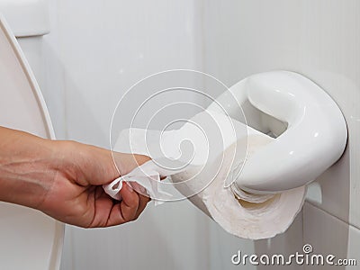 Soft focus woman hand picking a white tissue from tissue roll Stock Photo