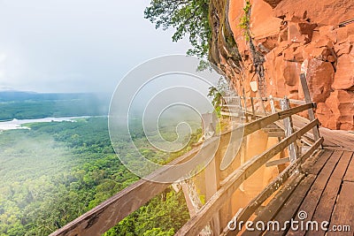 The soft focus of wooden bridge, balcony at mountain side, the women,green forest foggy hills at Phu Tok ,Bung Kan province, Thail Stock Photo