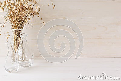 Soft home decor of glass vase with spikelets on white wood background. Stock Photo