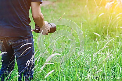 Soft Light and Blurred image, A photographer capturing the beautiful Grass flowers in the evening with a DSLR camera, Stock Photo