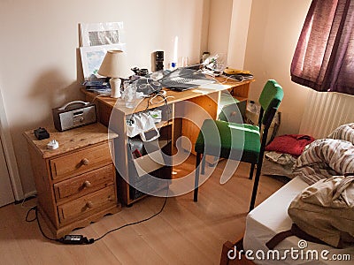 Soft light lit student bedroom desk and chair clutter messy Editorial Stock Photo