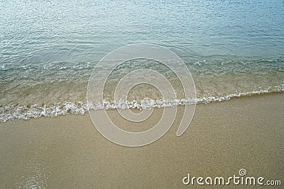 Soft pastel clean sandy beach with fresh sea water and white foamy wave line background and copyspace on Ornos shore Stock Photo