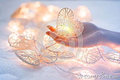 Soft pastel Orange Lamp in Bamboo baskets in the heart shape on Two hand Stock Photo