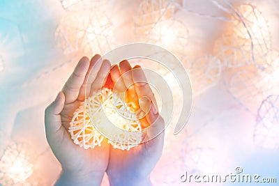 Soft pastel Orange Lamp in Bamboo baskets in the heart shape on Two hand Stock Photo