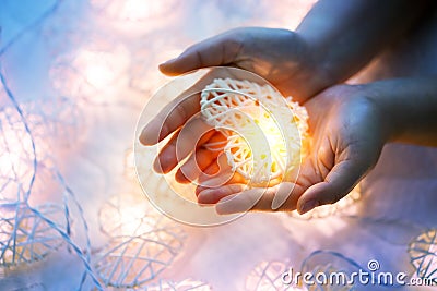 Soft pastel Orange Lamp in Bamboo baskets in the heart shape on Two hand Stock Photo