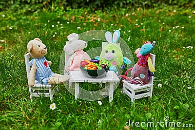 Soft toys having a dinner with clay figurines of fruits and vegetables Stock Photo