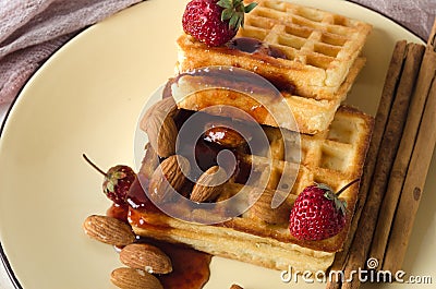 Soft waffles jam almonds strawberries yellow plate Stock Photo