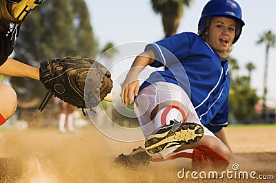 Softball Player Sliding Into Home Plate Stock Photo