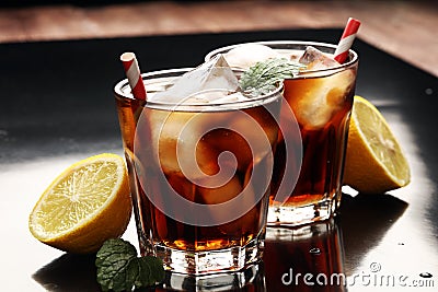 Softdrink with ice cubes, lemon and straw in glass Stock Photo