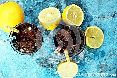 Softdrink with ice cubes, lemon and straw in glass. Stock Photo