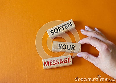 Soften your Message symbol. Concept words Soften your Message on wooden blocks. Beautiful orange background. Businessman hand. Stock Photo