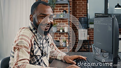 Software developer typing programming code on computer keyboard turning head and smiling Stock Photo