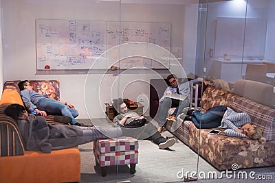 Software developers sleeping on sofa in creative startup office Stock Photo