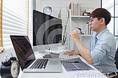 Software development concept, Male programmer checking website programming and drinking coffee Stock Photo