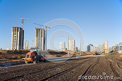 Soil Compactor during road construction at the large scale construction site. Vibration single-cylinder road roller Stock Photo