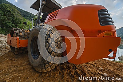 Soil compactor with vibratory padfoot drum. Heavy duty machinery working on highway construction site. Vehicle for soil Stock Photo