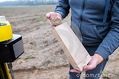 Soil Sampling. An engineer employee of a research laboratory packs a soil sample in a paper package. Automated probe for soil Stock Photo