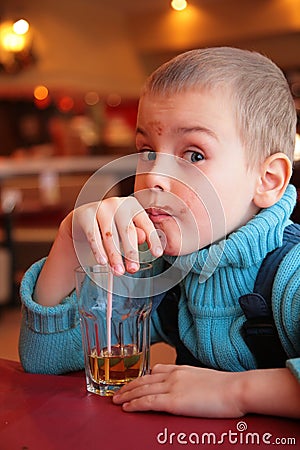 Soiled boy drinks juice from glass Stock Photo