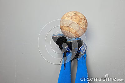 A soiled football on an upside down boots Stock Photo