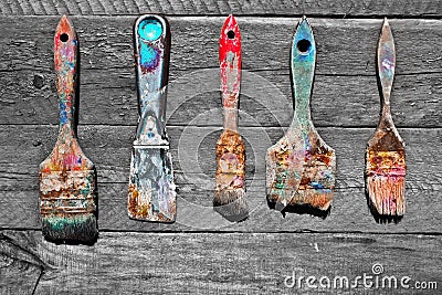 Soiled in a paint brush on unpainted natural wooden background. Stock Photo