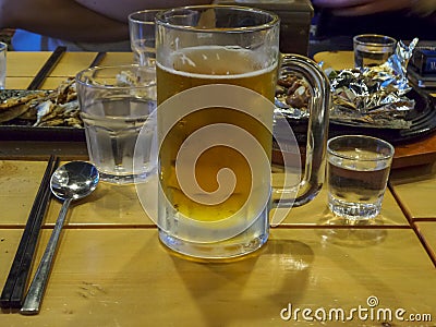 Soju glasses full of soju and a beer glass full of beer with korean side dishes at the year-end party in korea Stock Photo