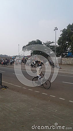 An old man with white cap drives cycle on sunny days Editorial Stock Photo