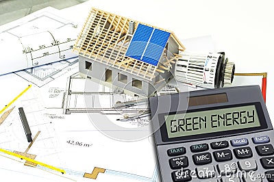 Solar energy cells on a blueprint or construction plan with calculator showing the word green energy Stock Photo