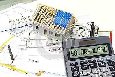 Solar energy cells on a blueprint or construction plan with calculator showing the word solar plant Stock Photo