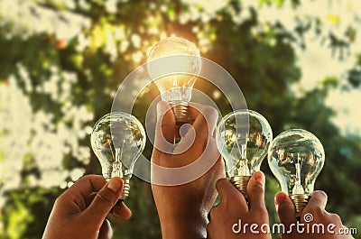 solar energy concept hand group holding light bulb Stock Photo