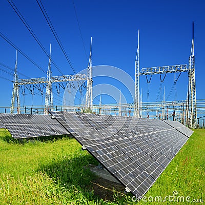 Solar energy panels in the background high voltage power substation. Stock Photo