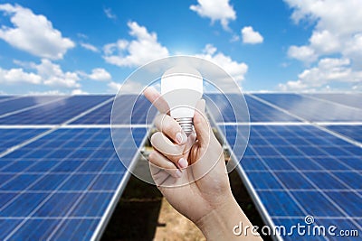 Solar energy panels and Light bulb in hand, energy Stock Photo