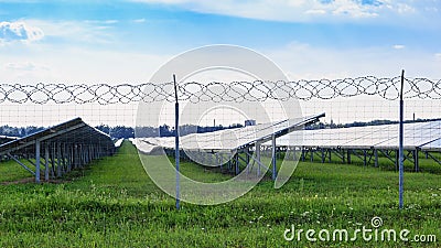 Solar panel on blue sky background. Green grass and cloudy sky. Stock Photo