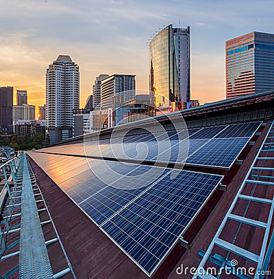 Solar Panel Photovoltaic installation on a Roof of factory, sunny blue sky background, alternative electricity source - Stock Photo
