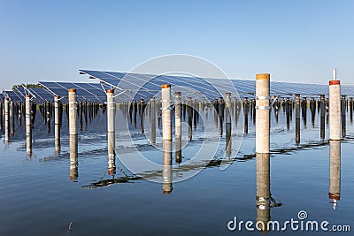 Solar panels and concrete columns over the fish pond Stock Photo