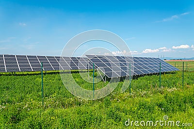 Solar panels in the field with blue sky produces renewable energy from the sun Stock Photo