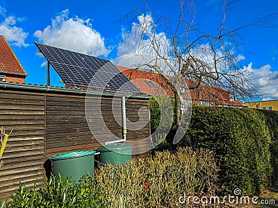 Solar panels of photovoltaic powerplant at the roof of a shed in the garden Stock Photo