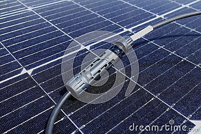 Solar PV Connectors Male and Female connected together laid on Solar Panel Surface Stock Photo