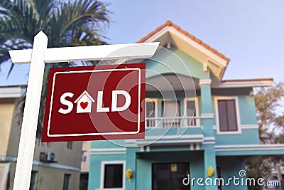 Sold sign in front of a quaint two story house. Prime real estate advertised as purchased Stock Photo