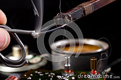 Soldering of an integrated circuit in an electronics workshop. Small electronic works Stock Photo