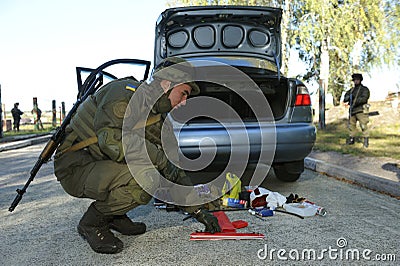 Soldier conducting a search of a stopped car. Checkpoint, training. Novo-Petrivtsi military base, Ukraine Editorial Stock Photo