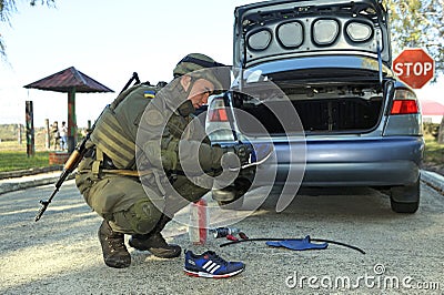 Soldier conducting a search of a stopped car. Checkpoint, training. Novo-Petrivtsi military base, Ukraine Editorial Stock Photo