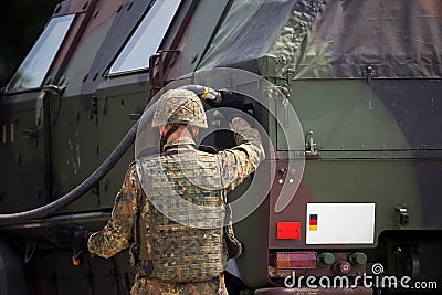 Soldier fuels a military armored truck Stock Photo