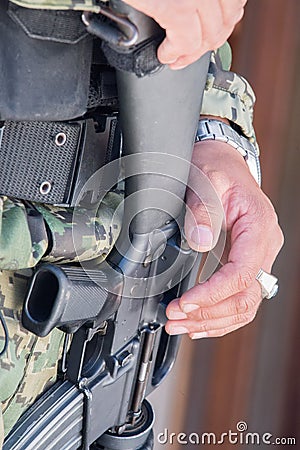 Soldier hands holding machine gun Stock Photo
