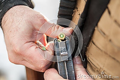 Soldier hands load rifle machine gun bullets into cartridge clip Stock Photo