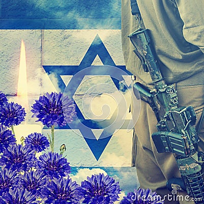 Soldier of Israeli defense forces on Israeli national flag, wall and sky background. Ceremonial burning candle and blue flowers. M Stock Photo