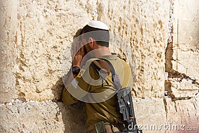 Soldier praying at the Wailing Wall with weapon, Jerusalem, Israel Editorial Stock Photo