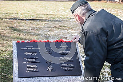 Soldier putting remembrance poppy on the plaque to Nathan Cirillo, victim of the 2014 terrorist shootings on National War memorial Editorial Stock Photo