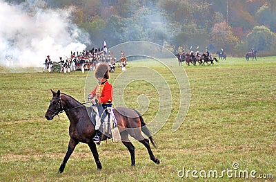 A soldier-reenactor rides a brown horse. Editorial Stock Photo