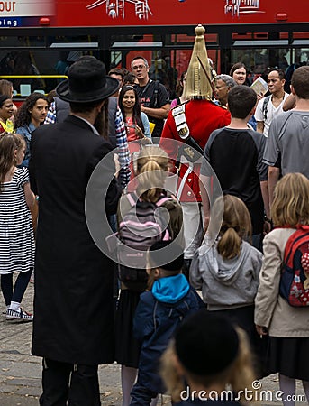 Soldier of Royal Horse Guards in London, surrounded by tourists including Jewish family in foreground Editorial Stock Photo