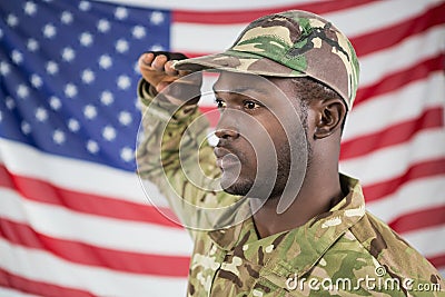 Soldier saluting against american flag Stock Photo